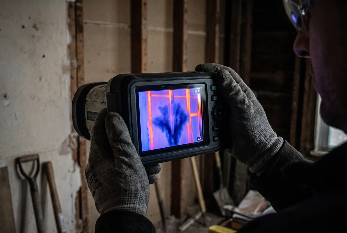 Thermal imaging camera screen showing a cold moisture plume spreading up inside a wall